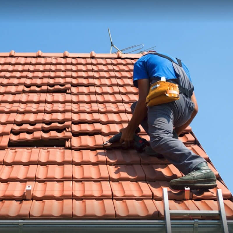 man setting the tiles on roof